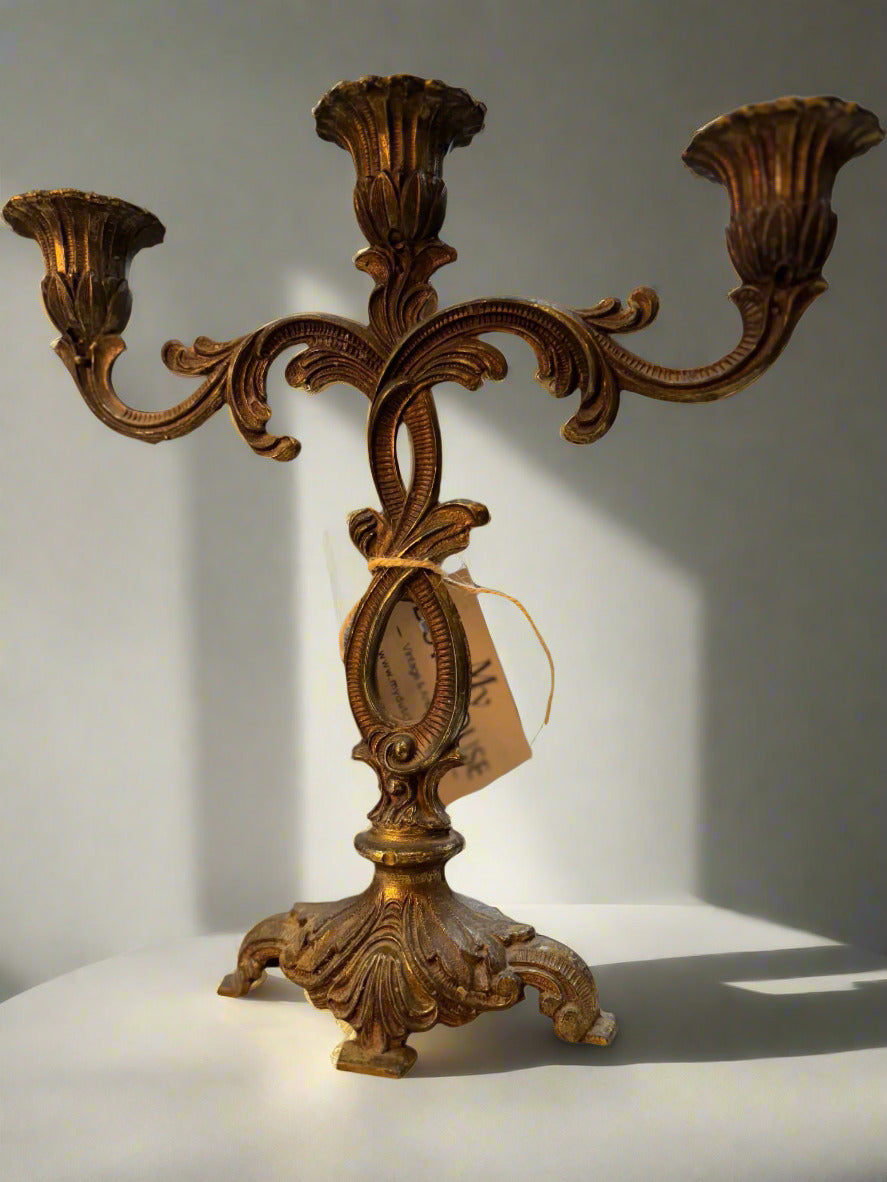 Vintage brass candleholder with bronze and gold finish, holds three candles, ornate decorative design